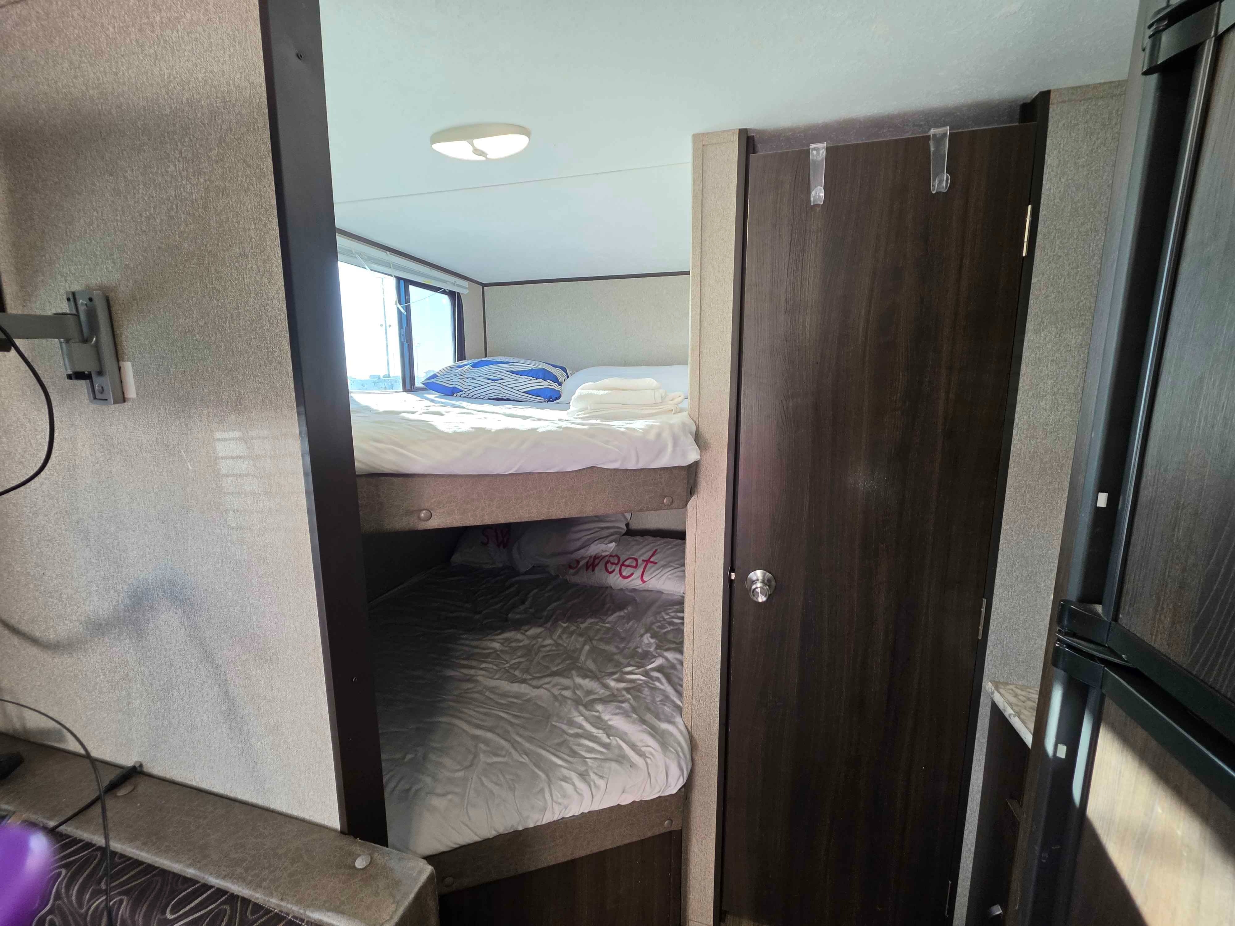 Comfortable RV rental bunk beds, fully made and ready for a good night's sleep in this compact travel trailer.. Keystone RV Springdale SSR 2018