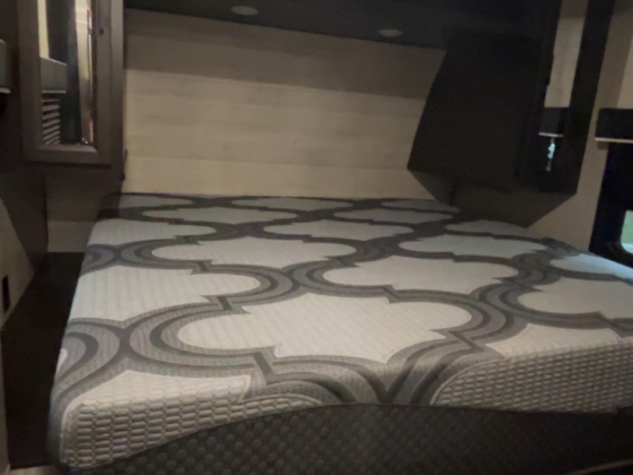 Explore this RV rental's cozy bedroom, featuring a comfortable bed with a modern patterned mattress.. Jayco Jay Flight 2023