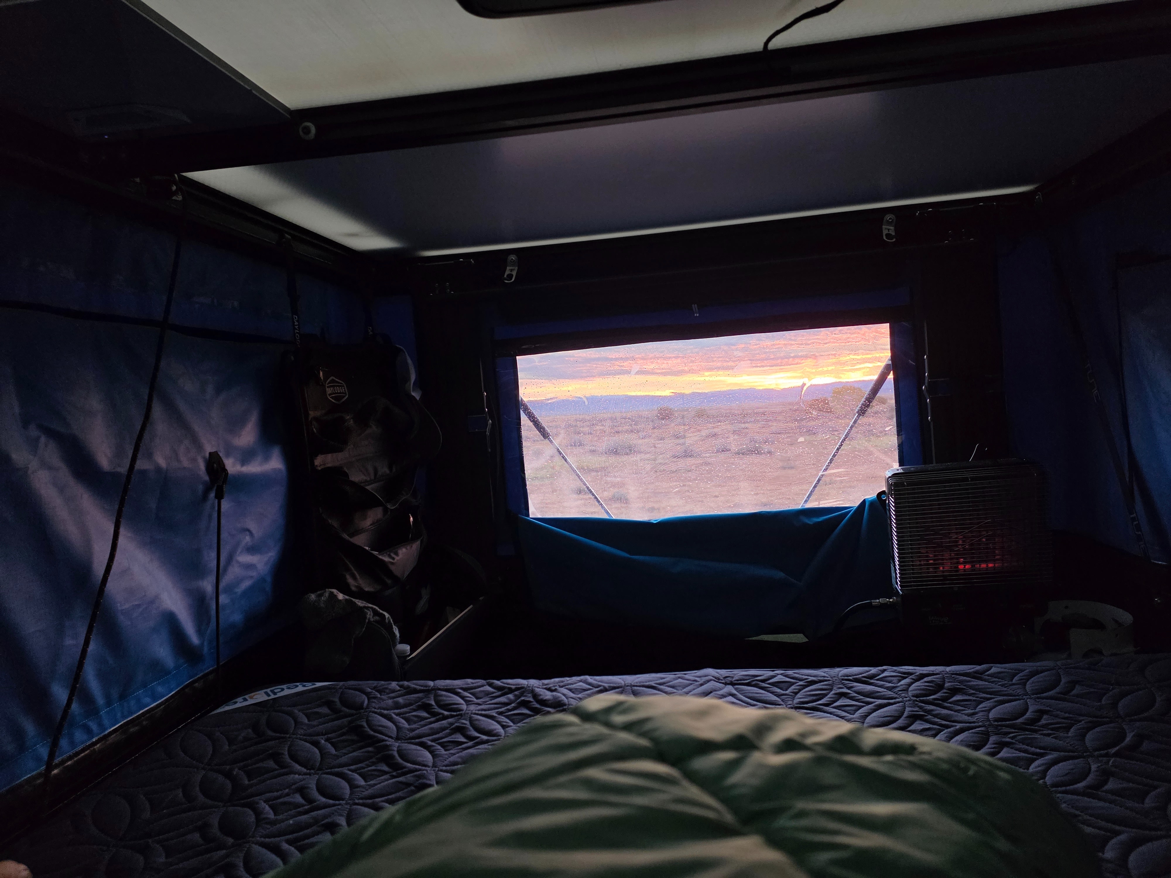 Cozy rv rental setup with a stunning desert sunrise view and warm heater. Perfect for travel camping.. Jeep Gladiator 2020