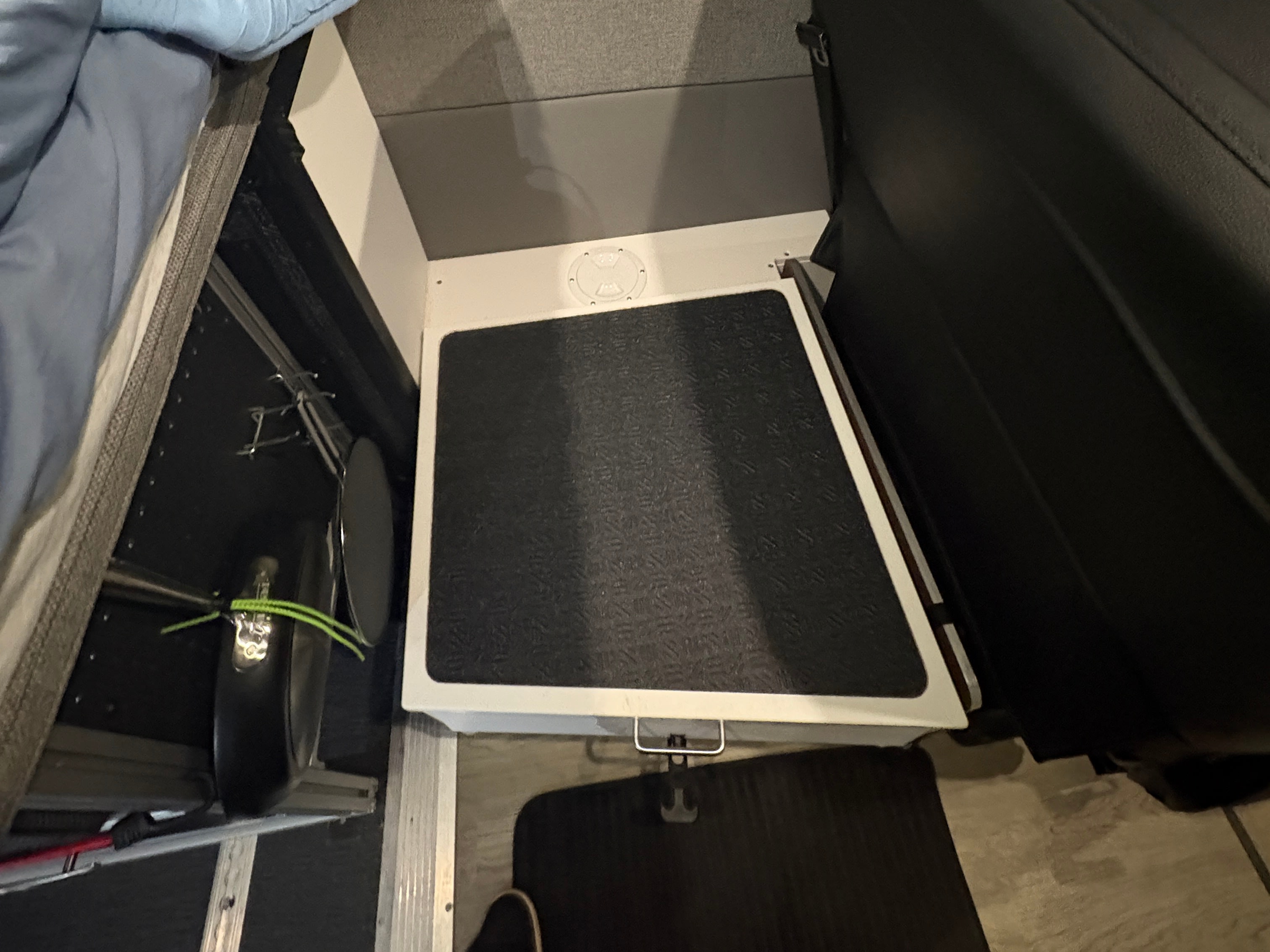 View inside an RV rental, featuring a step with a non-slip mat, under-bed storage, and compact living design.. Storyteller Overland Storyteller Overland Class B 2024