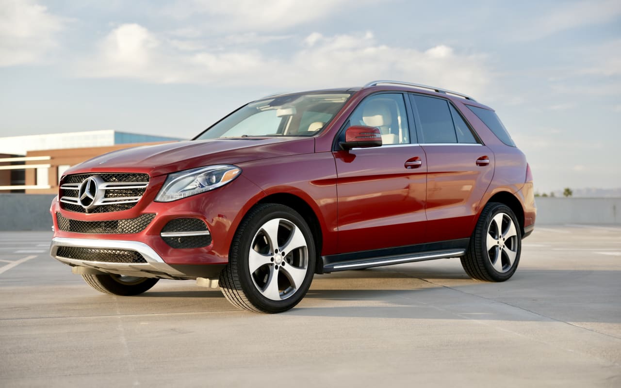 A shiny red Mercedes-Benz GLE luxury SUV, perfect for car rental, parked on a sunlit concrete lot