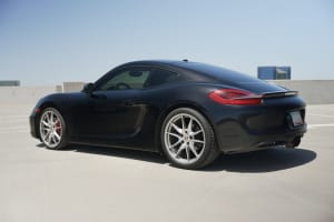 Black Porsche sports car, perfect for a luxury car rental, on a sunny rooftop