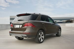 Brown Mercedes-Benz GLE 350 4MATIC SUV, ideal for car rental, parked on a concrete lot with buildings