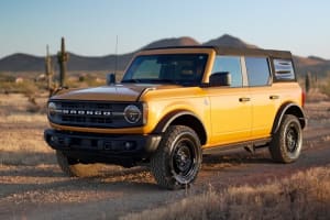 A yellow Ford Bronco SUV on a desert trail