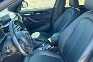 View of a modern car's black leather interior, steering wheel, and dashboard, ready for a trip
