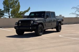 A rugged grey Jeep Gladiator pickup truck in a sunny parking lot