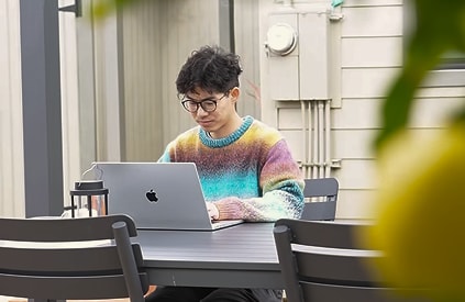 Brian working on a laptop at a table in a Haven pavilion