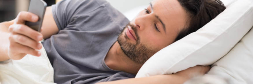 man in bed on phone