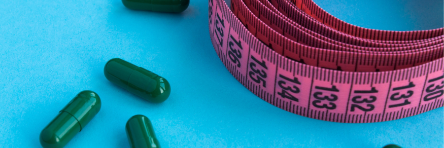 green tablets and pink measuring tape on a blue background