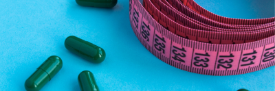 green tablets and pink measuring tape on a blue background