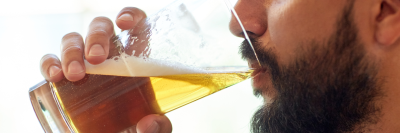 Bearded man drinking a pint of beer