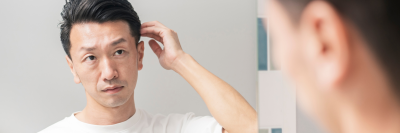 Man looking in the mirror and checking his hair