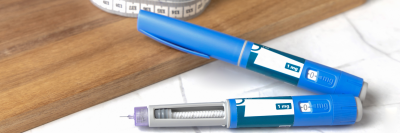 Two weight loss pens on marble and wood surface