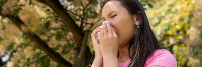 woman with pink top blowing nose