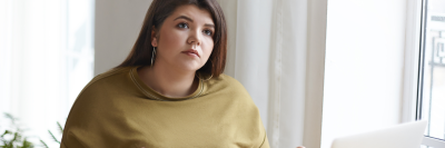 Woman looking pensive at laptop