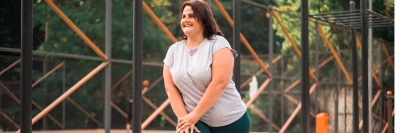 woman smiling and working out in an outside gym