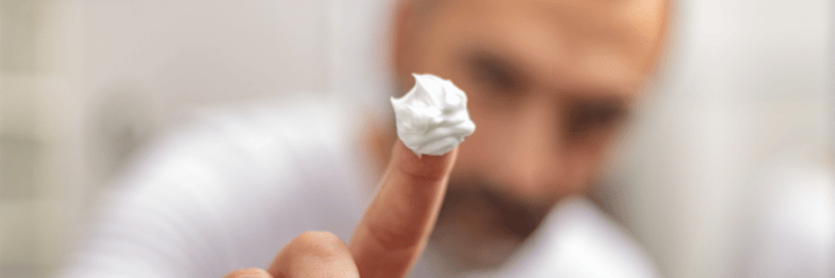 Man holding up dolop of cream