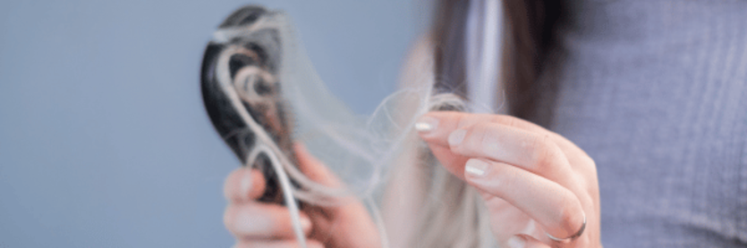 woman noticing early signs of hair loss