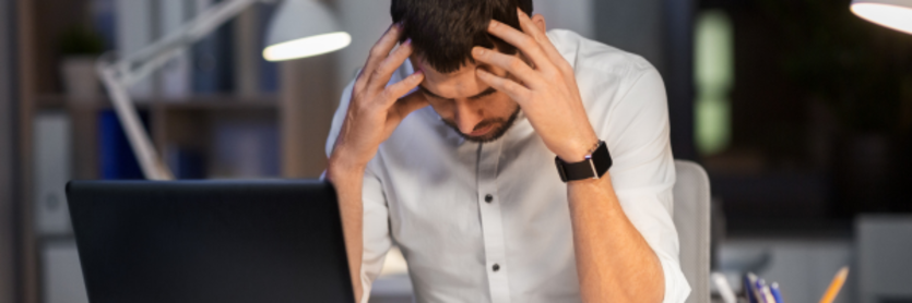 Man stressed with head in hands