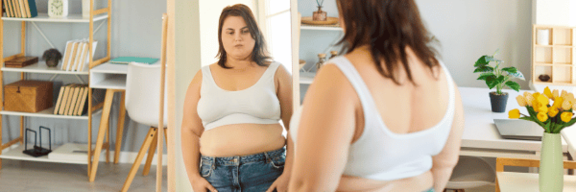 woman looking in mirror before using wegovy
