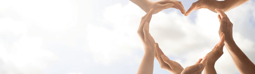 Love heart being formed by multiple hands into the sky