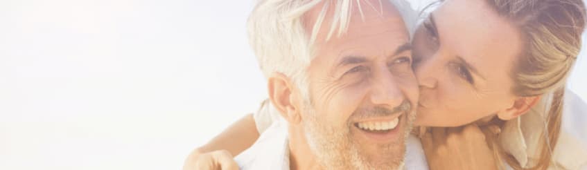 Happy couple with woman kissing a man on the cheek