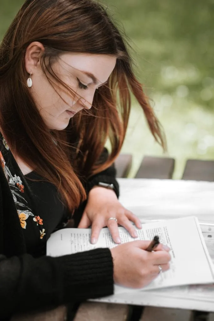 student-sat-outdoors-writing-notes