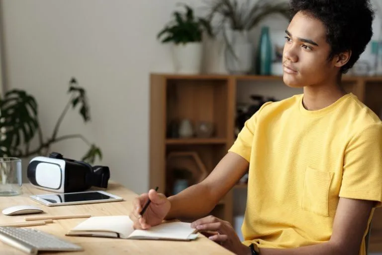 boy-looking-at-computer-writing-notes