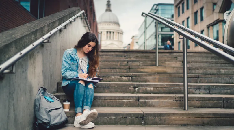 student-sat-on-steps-outdoors-in-london-on-laptop