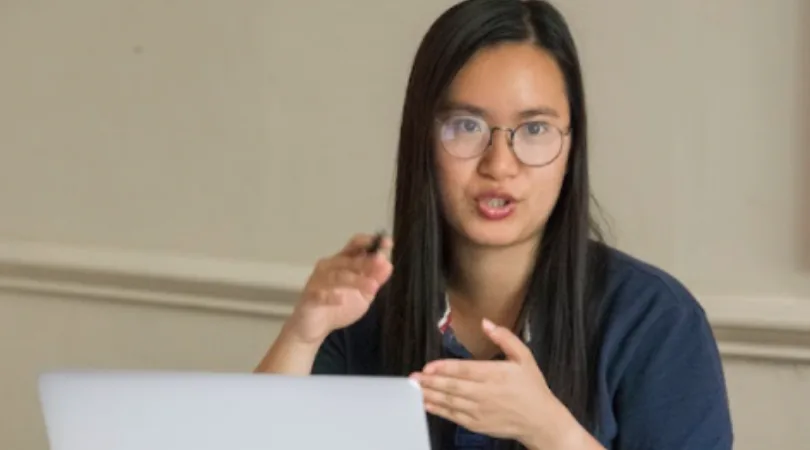 student-talking-in-front-of-open-laptop