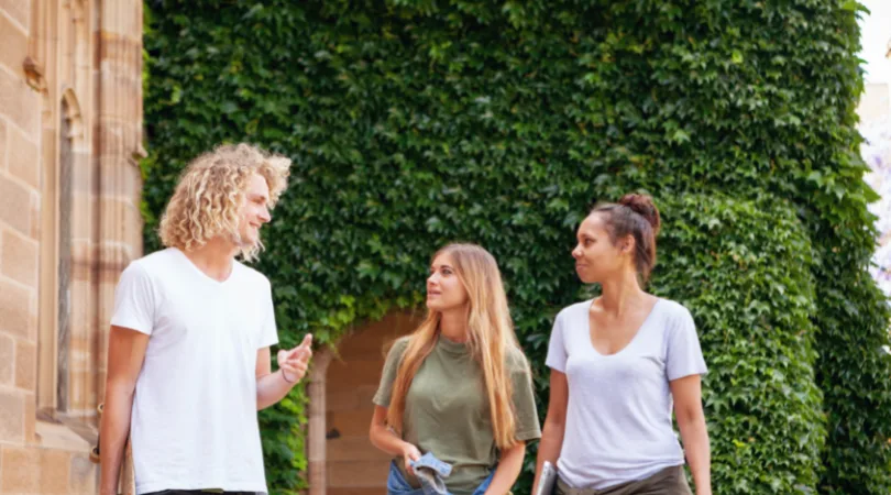 three-students-walking-talking-outside