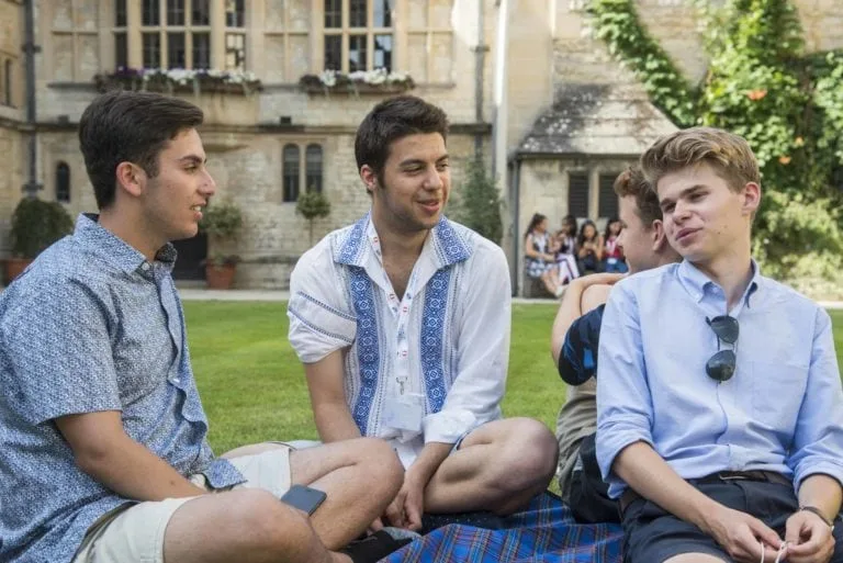 oxford-summer-courses-students-sat-outside-socialising-on-lawn