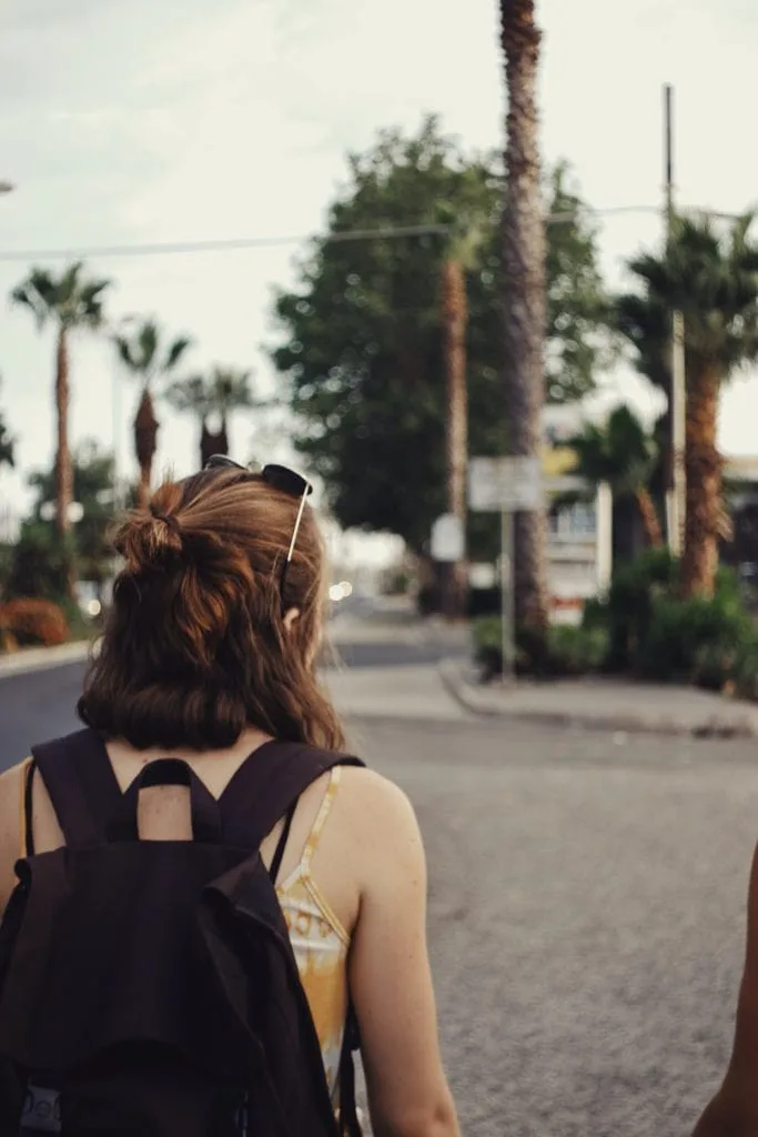 female-student-walking-outdoors-with-backpack