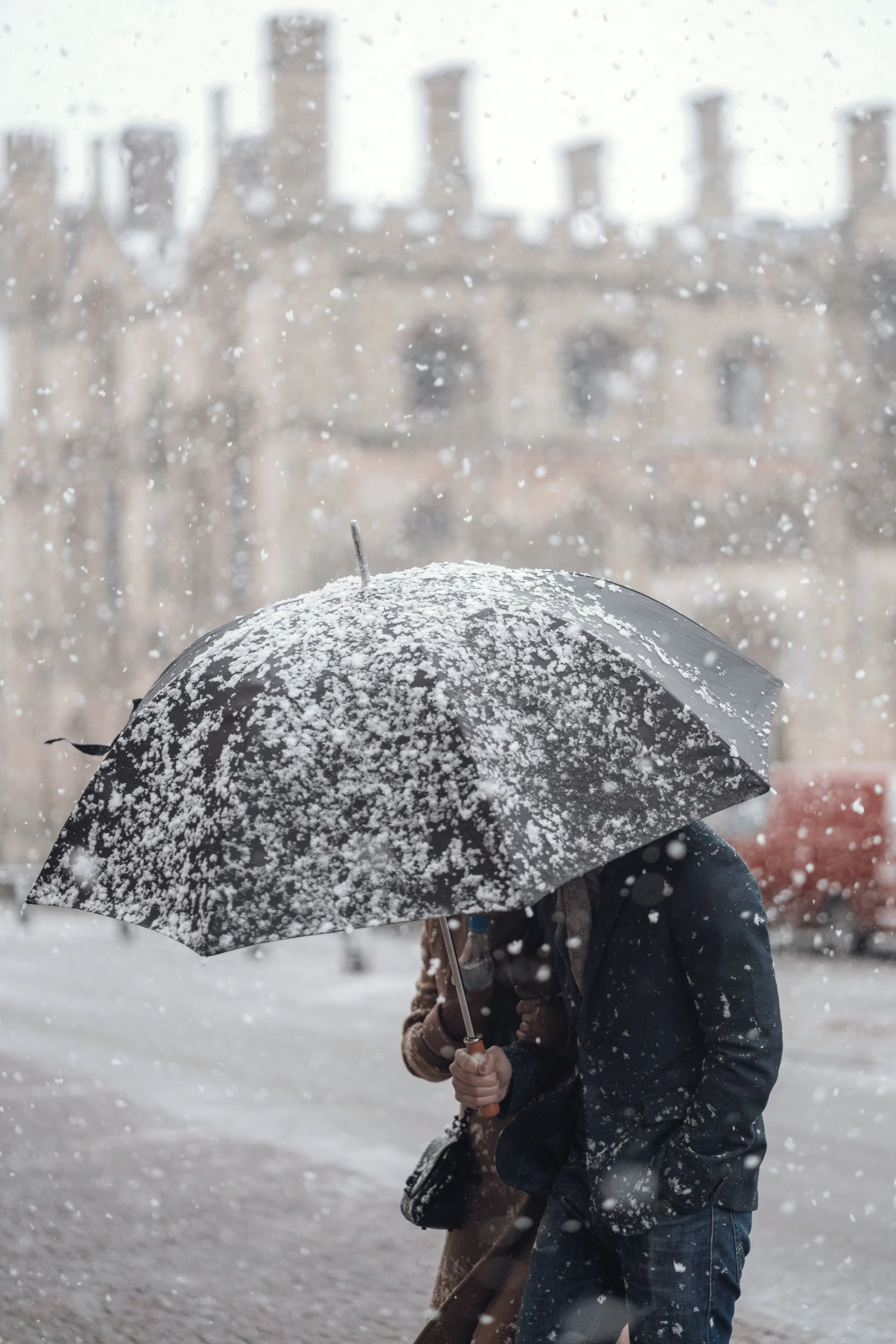 person-walking-through-cambridge-with-umbrella-in-snow