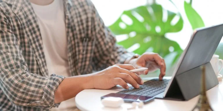 person-in-black-and-white-plaid-dress-shirt-using-macbook