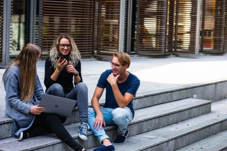 students-sat-outdoors-looking-at-laptop