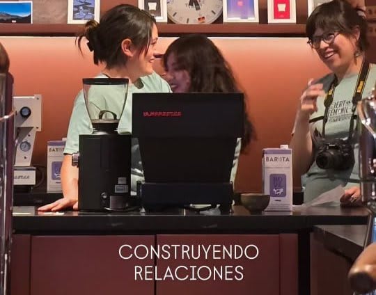 Baristas chat and laugh behind the bar