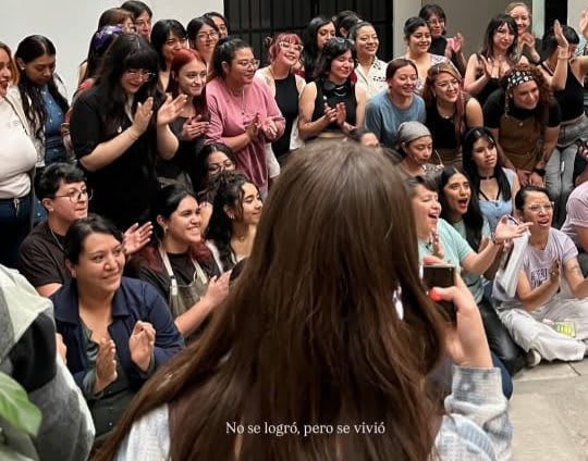 A participant, seen from behind, facing an applauding crowd