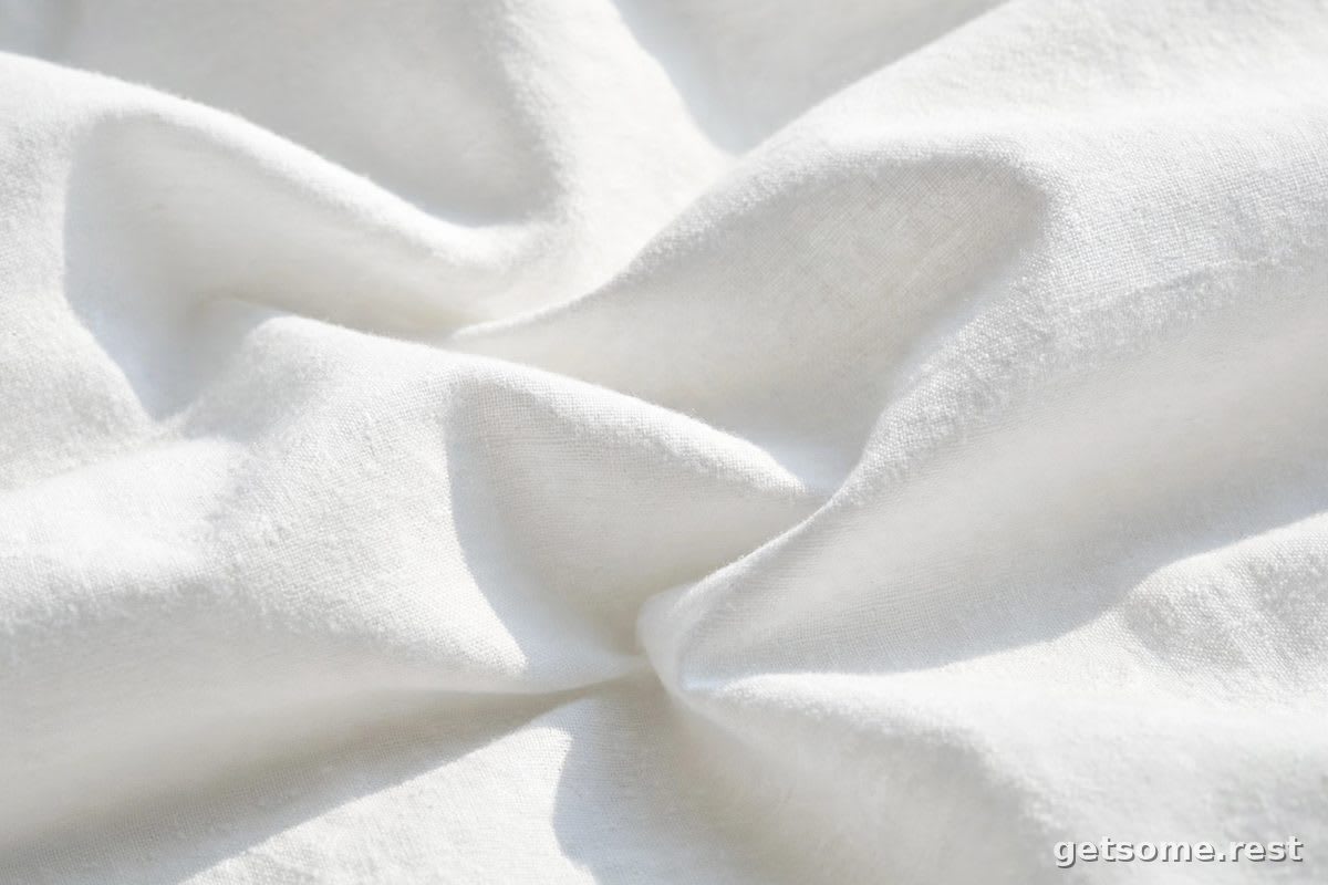 Close-up of breathable white cotton bed sheets