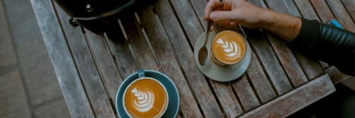 Top down view of two flat whites with patterns in the milk