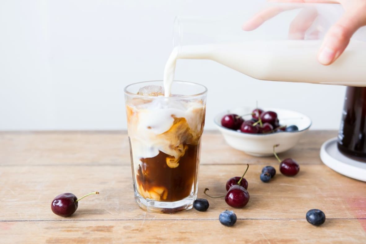 Pouring milk into iced coffee
