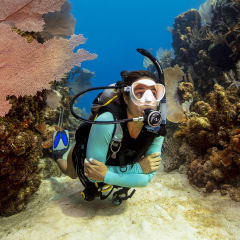 Scuba diver exploring coral reef with instructor nearby