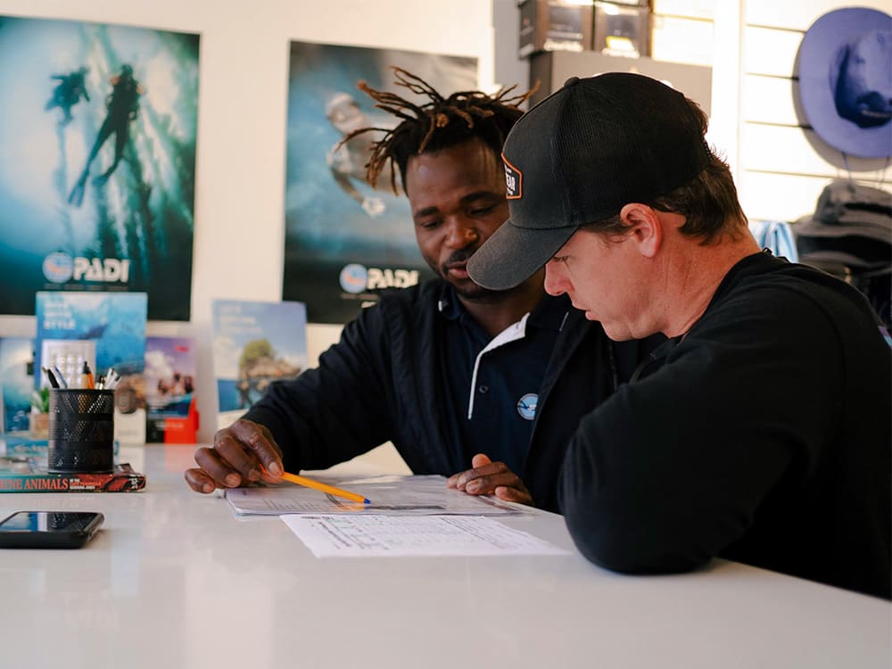 Student and instructor sitting at a desk reviewing.