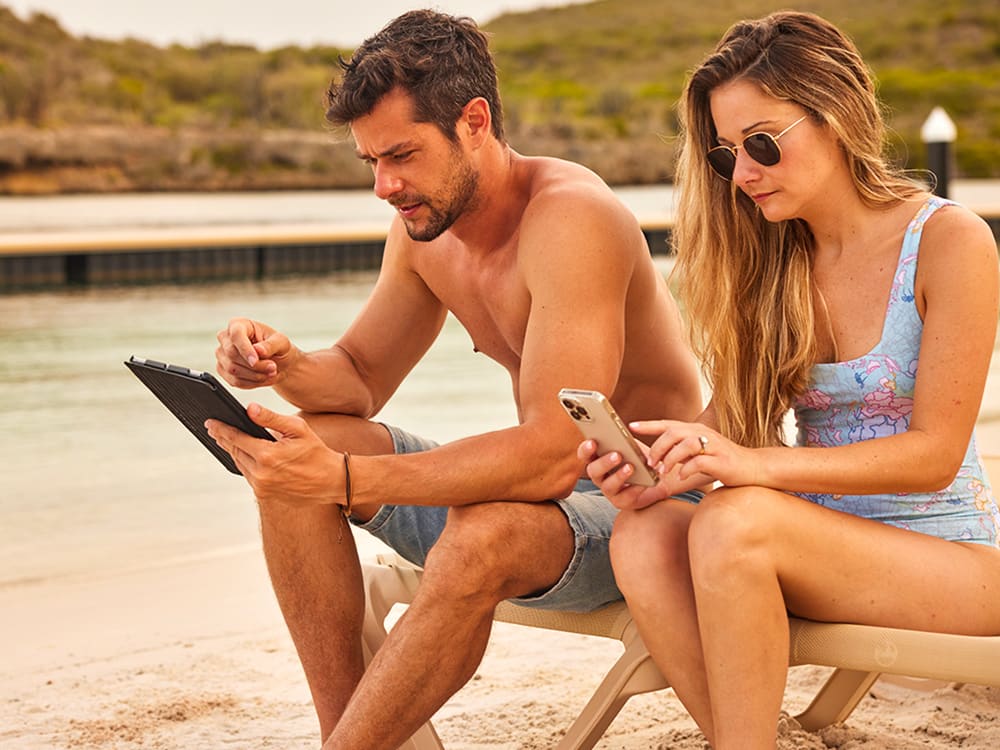 Man and woman sitting together using mobile devices