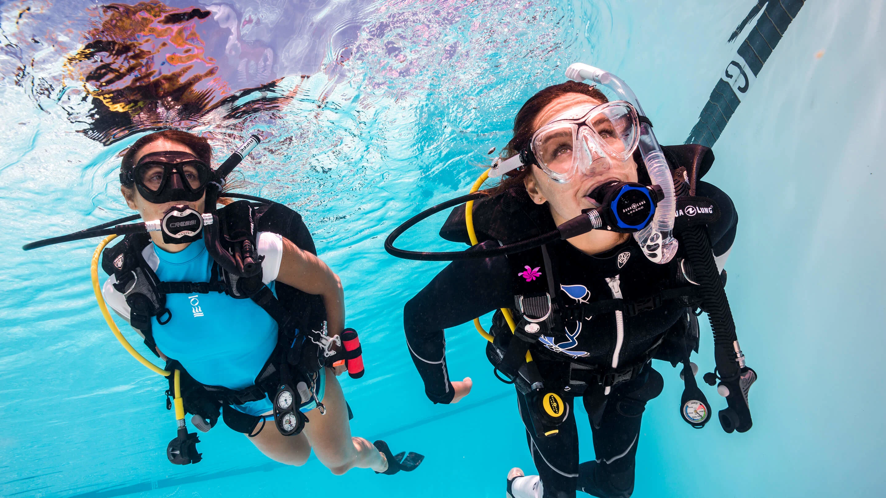 Two divers practicing in the pool