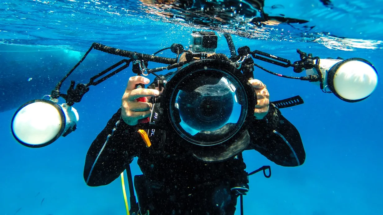 Diver with an underwater camera and strobes
