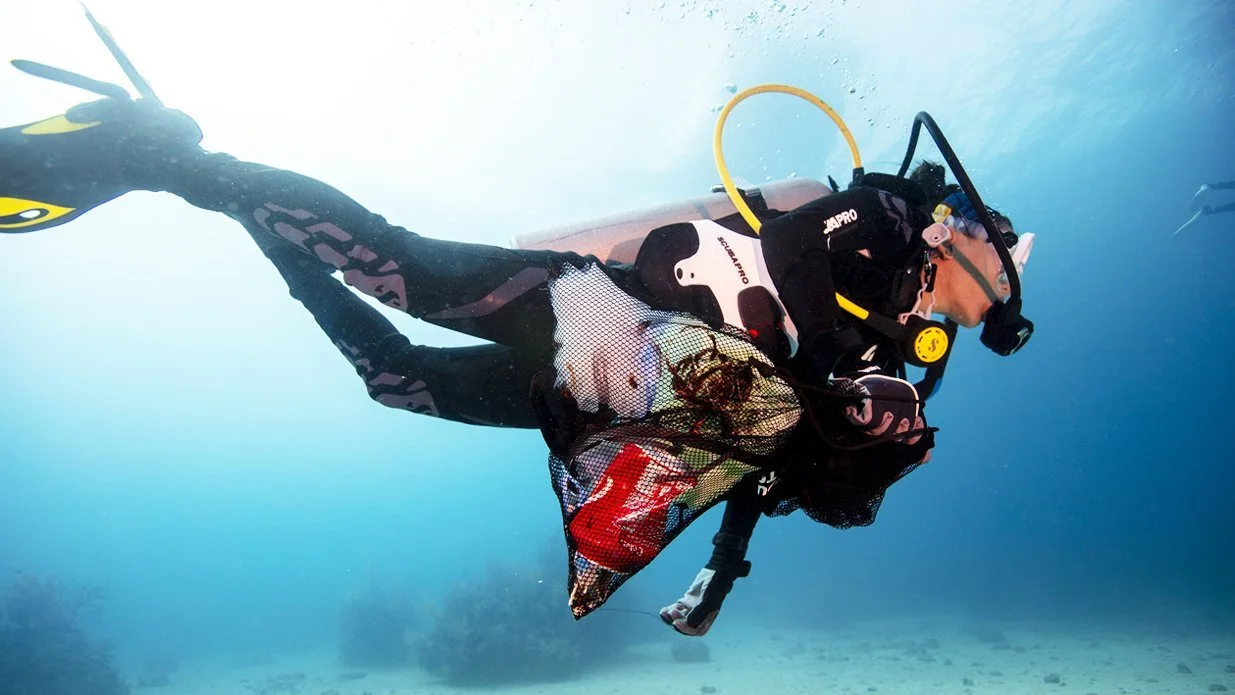 A diver picking up debris.