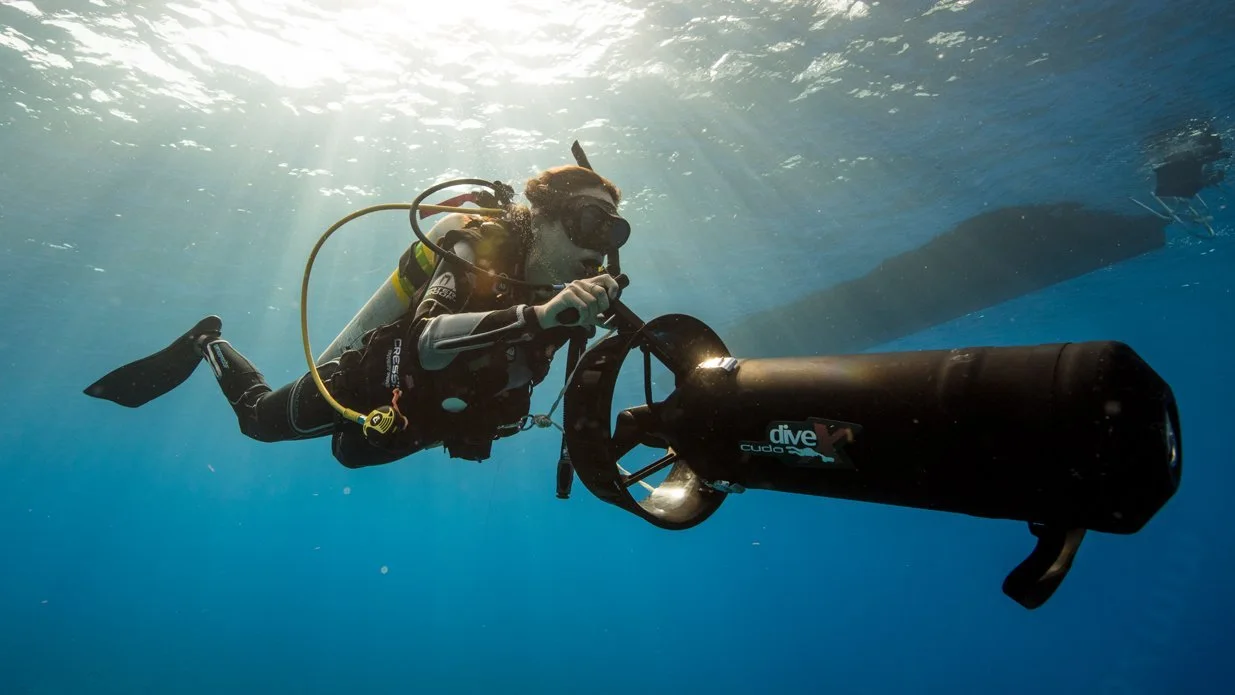 A close up of a diver using a diver propulsion vehicle.