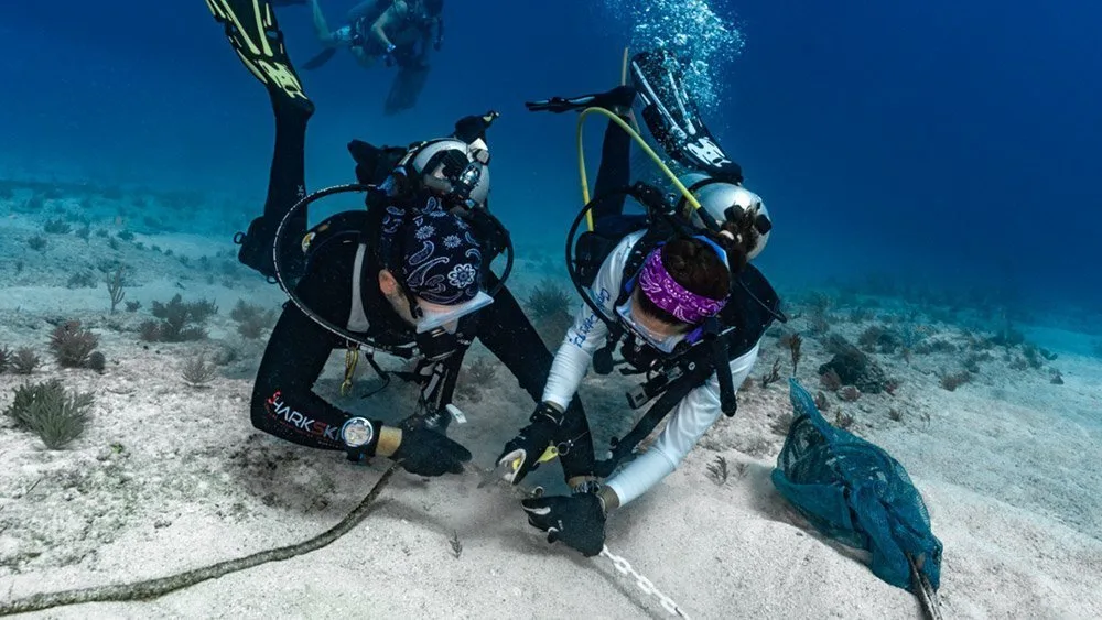Two divers removing ocean debris