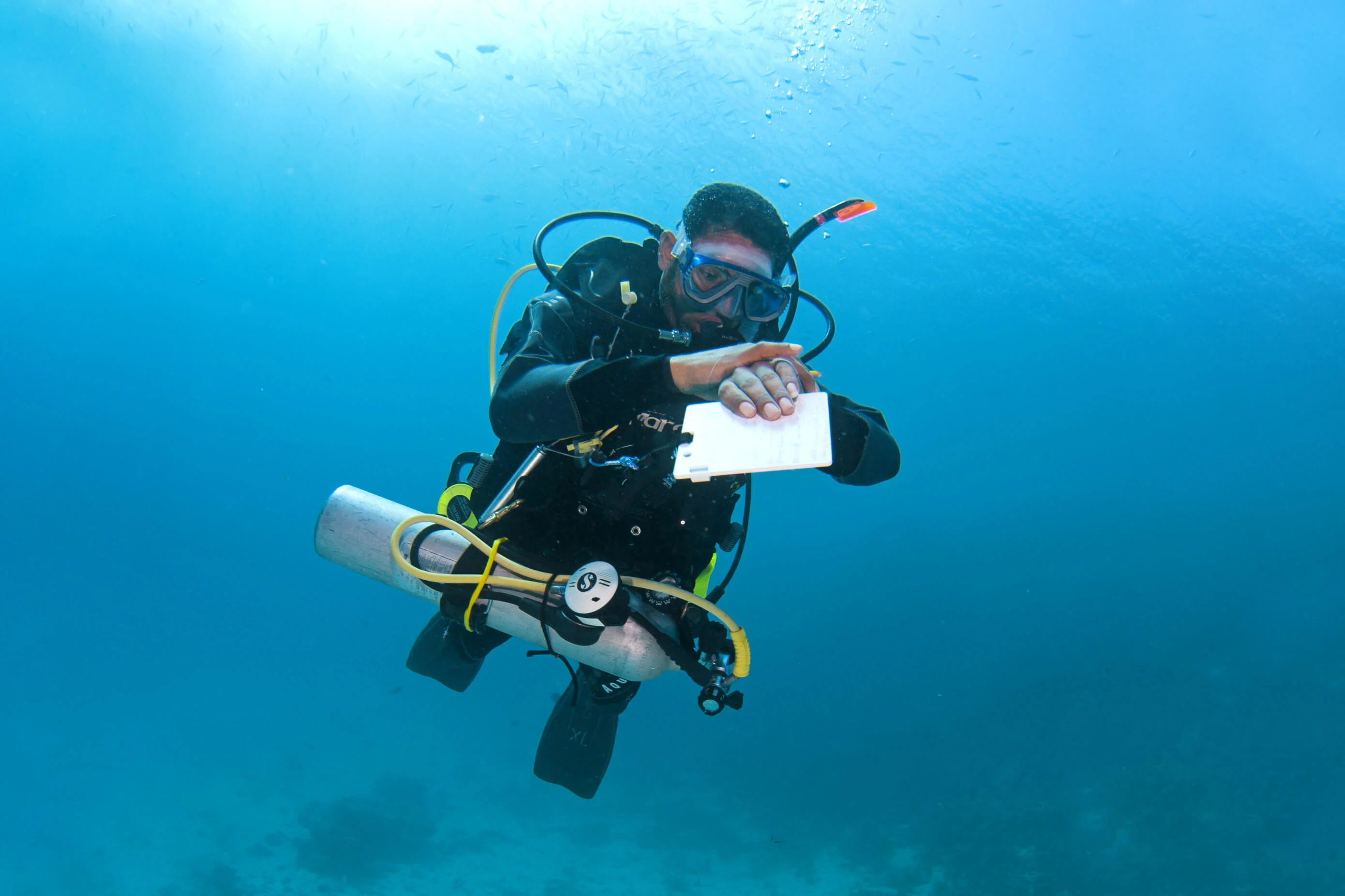 Diver with dive slate and pony bottle